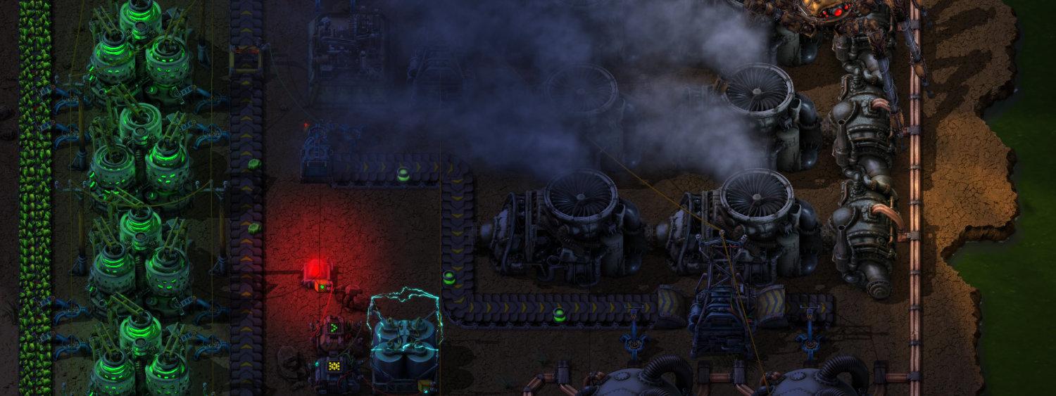 A top-down Factorio base at night, chemical plants and belts lit up beside the factory's defenses